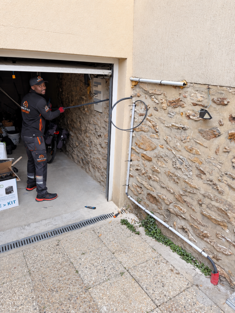 Électricien Diene et Fils Comfort passant une gaine électrique en façade d'une maison en meulière
